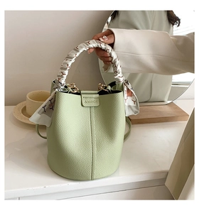 Detail of mint green lychee grain leather bucket bag with silk scarf wrapped handle