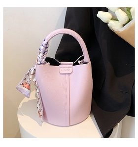 Detailed close-up of light purple lychee leather bucket bag with silk scarf on handle