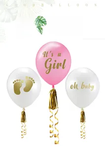 Detail of gender reveal balloons with It's a Girl and Oh Baby prints and gold tassels