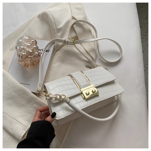 Detailed view of white crocodile pattern crossbody bag with gold buckle and fashion hardware