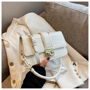 Close-up of white croc-embossed crossbody bag featuring gold hardware and chain strap