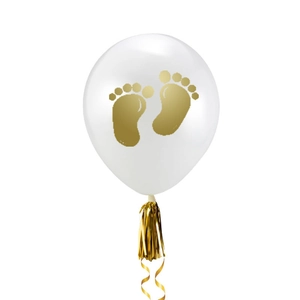 Close-up of white latex balloon with golden baby footprints and decorative fringe tassel