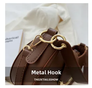 Detailansicht der goldenen Hardware und Ringe an der dunkelbraunen Leder-Schultertasche