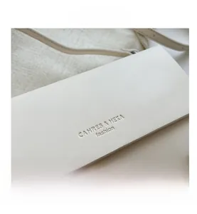 Detail of creamy white faux leather texture and embossed logo on the stylish handbag