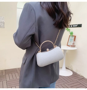 Détail du sac de soirée argenté avec poignée en strass et bandoulière chaîne dorée