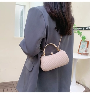 Détail du sac de soirée champagne élégant avec poignée en métal et texture raffinée