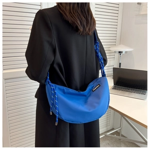 Close-up of royal blue nylon hobo bag with distinctive blue and white braided rope strap