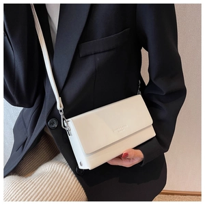 Detail view of a white rectangular crossbody bag with silver hardware and fashion logo text