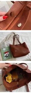 Detail of brown litchi pattern leather tote bag showing large capacity and magnetic closure