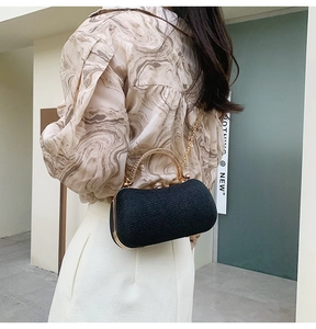 Détail de la pochette de soirée noire avec poignée en strass et chaîne dorée