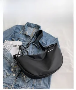 Detail of black oxford nylon crossbody bag featuring braided strap and Fashion logo label