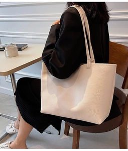 Close-up of off-white tote bag with premium lychee grain texture and long shoulder straps