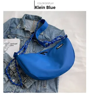 Detail of Klein Blue crescent nylon crossbody bag with woven rope strap and fashion label