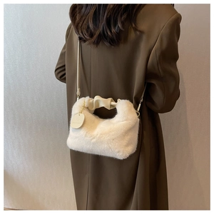 Detail of white faux fur handbag with beige gathered handle on brown blazer outfit