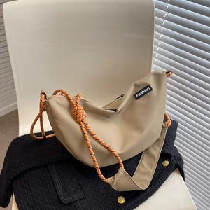 Chic beige nylon crescent bag with woven rope strap and fashion patch on textured coat
