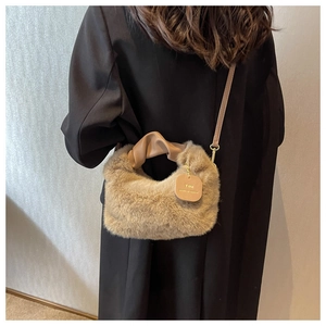 Detail of plush faux fur handbag with leather handle and You Deserve Better tag