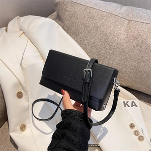Minimalist black leather crossbody bag with chain strap and adjustable shoulder design