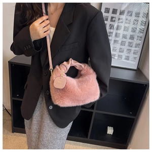 Close-up of pink faux fur crossbody bag featuring leather handle and metal chain details