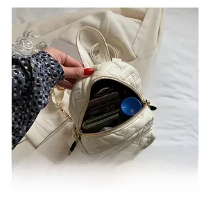Detail showing the inner capacity of this cream white heart-quilted mini backpack