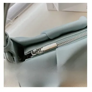 Detail showing the smooth silver metal zipper on a mint green ruched leather bag