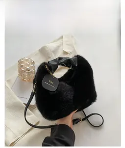 Detail of black faux fur bag with pleated leather handle and gold chain accessory