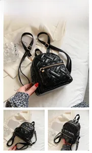 Detail of black quilted mini backpack featuring heart embroidery and gold zipper accents