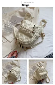 Detail view of beige quilted backpack featuring heart stitching and gold metal hardware