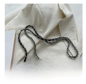 Detail of black quilted leather shoulder bag with silver metal and leather chain strap