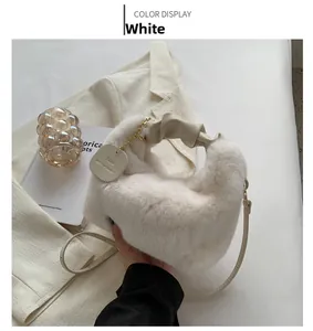 Detail of white fluffy faux fur handbag with knotted handle and golden metal chain