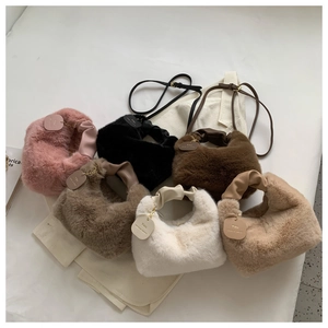 Detail view of plush handbags in six colors with pleated leather handles and brand tags