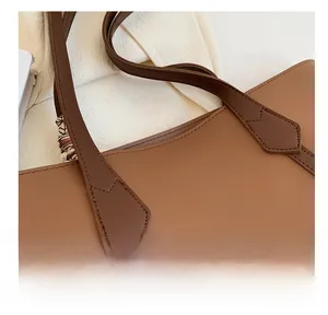 Gros plan des coutures renforcées sur un sac cabas en cuir marron au design minimaliste