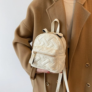 Chic beige quilted mini backpack with heart patterns and elegant bow detail for women