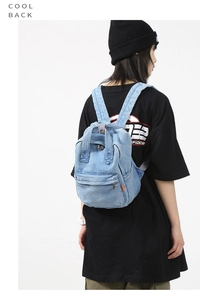 Detailed side view of light blue denim backpack with pockets and metal zipper closure
