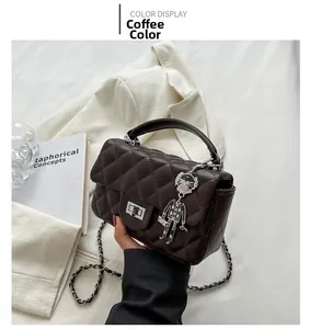 Brown quilted leather shoulder bag with metallic lock and robot cat charm detail