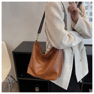 Dettaglio della borsa hobo marrone vintage con tracolla jacquard colorata in stile boho