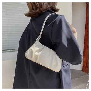 Detail view of the beige pleated cloud bag showing the soft texture and shoulder strap