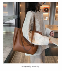 Brown large capacity soft PU leather tote bag styled with a white cable knit sweater