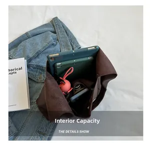 Intérieur spacieux du cabas en cuir marron foncé avec poche zippée pour les tablettes