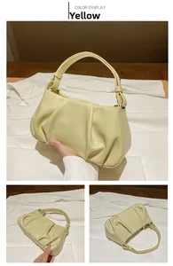 Detail view of the yellow pleated cloud bag showing the soft texture and structure