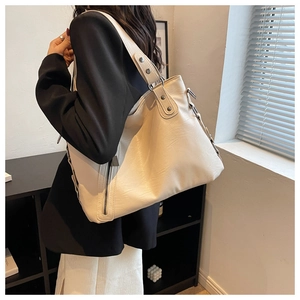 Detail of off-white oversized tote bag showing natural faux leather texture and metal zipper
