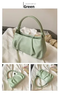 Detail of light green pleated cloud bag with soft leather texture and stylish top handle