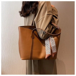 Détail du cabas couleur camel en similicuir avec un foulard en soie sur l'anse