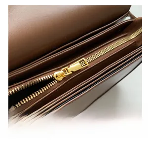 Detailed interior of a brown leather saddle bag featuring gold metal zipper and multi-compartments