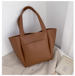 Detail view of large brown PU leather tote bag with wide straps and front pocket