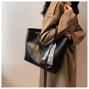 Détail du grand sac cabas noir avec foulard géométrique porté à l'épaule