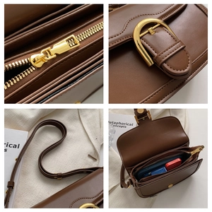 Detail view of gold-tone hardware and interior storage on a vintage brown saddle bag