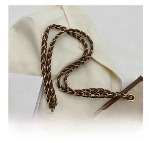 Détail de la bandoulière contrastée avec chaîne dorée et cuir marron tressé