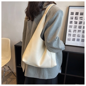 Gros plan d'un sac à bandoulière en cuir blanc cassé au design minimaliste et épuré