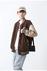 Detail view of American varsity jacket with brown wool body and cream faux leather sleeves