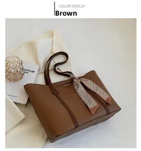 Détail d'un sac cabas en cuir marron avec foulard décoratif et design minimaliste chic